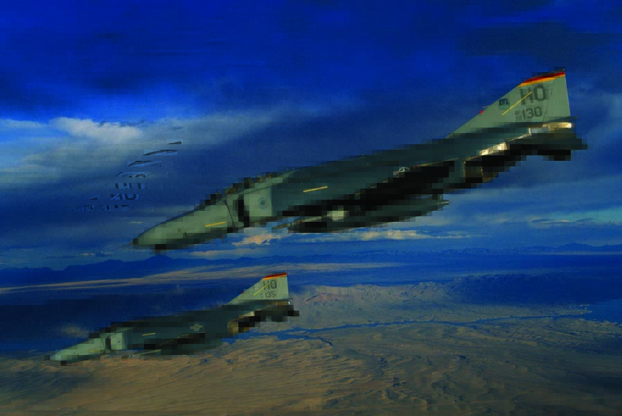 A pair of German-owned F-4F Phantom IIs fly over New Mexico during a training sortie. The German F-4Fs sported U.S. Air Force markings since they were based at Holloman AFB, New Mexico (for the better weather and ranges). Both U.S. and German instructors manned the unit, the 20th Fighter Squadron. (Photo by Ted Carlson/fotodynamics.com)
