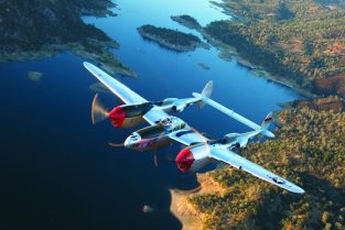 Lockheed P-38H “Honey Bunny” roars over the California landscape with the incomparable Steve Hinton at the controls. This is the only airworthy Lightning with fully functioning original turbo chargers and is now owned by Allied Fighters of Chino, California. Later during WW II, P-38s were flown in both theaters sans OD paint. (Photo by Paul Bowen)